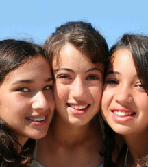 stock photo three teenage sisters sitting close together